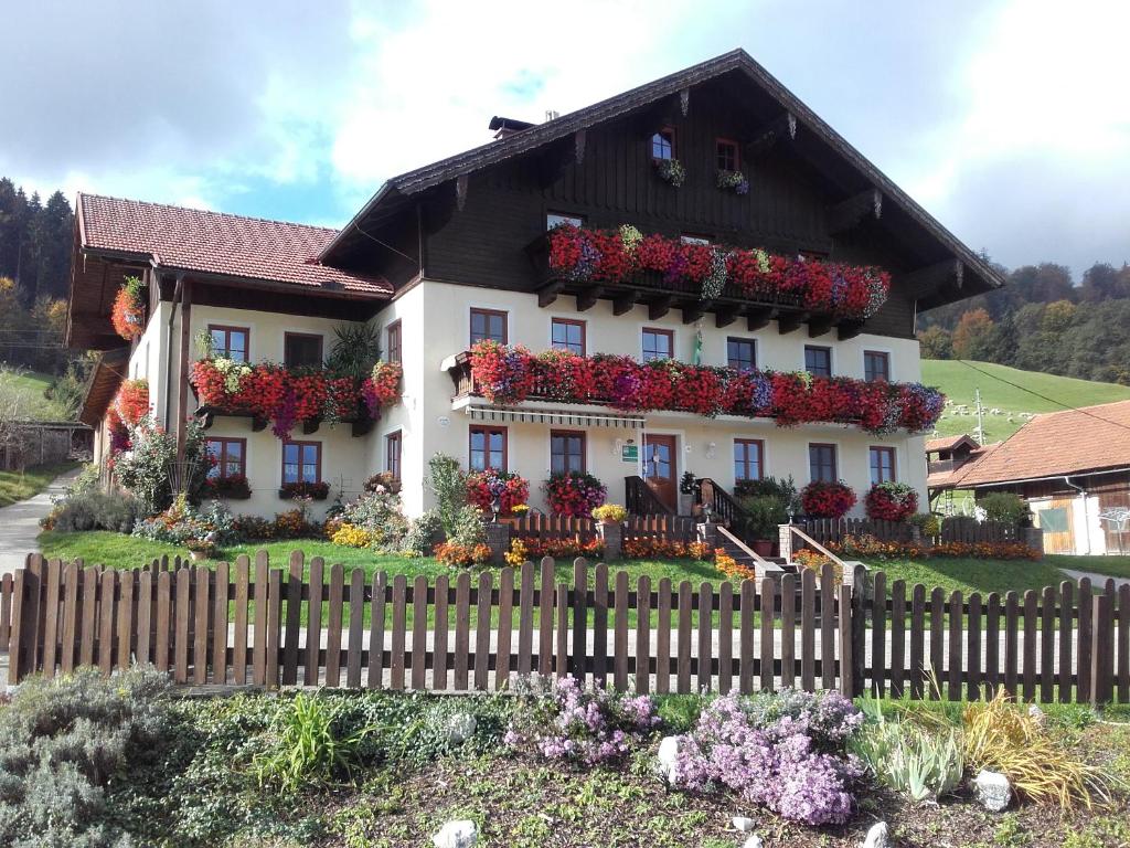 une maison avec des fleurs sur son côté dans l'établissement Nussbaumer am Irrsee, à Tiefgraben