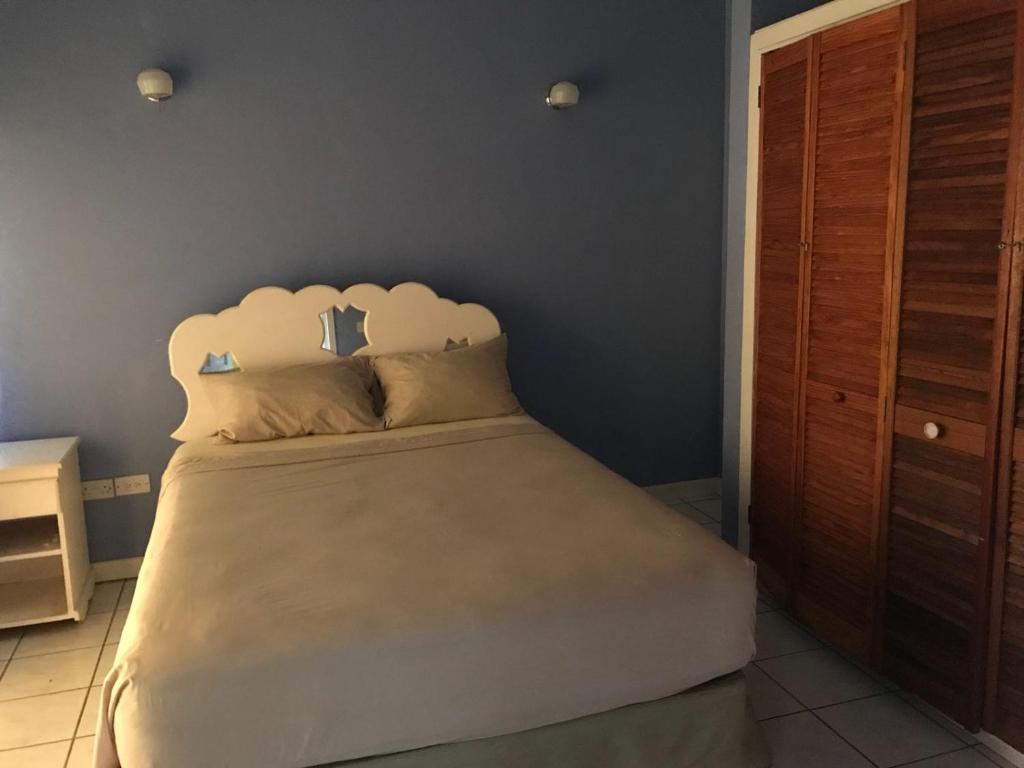a bedroom with a large bed with a white headboard at Marvey's Place in Castries