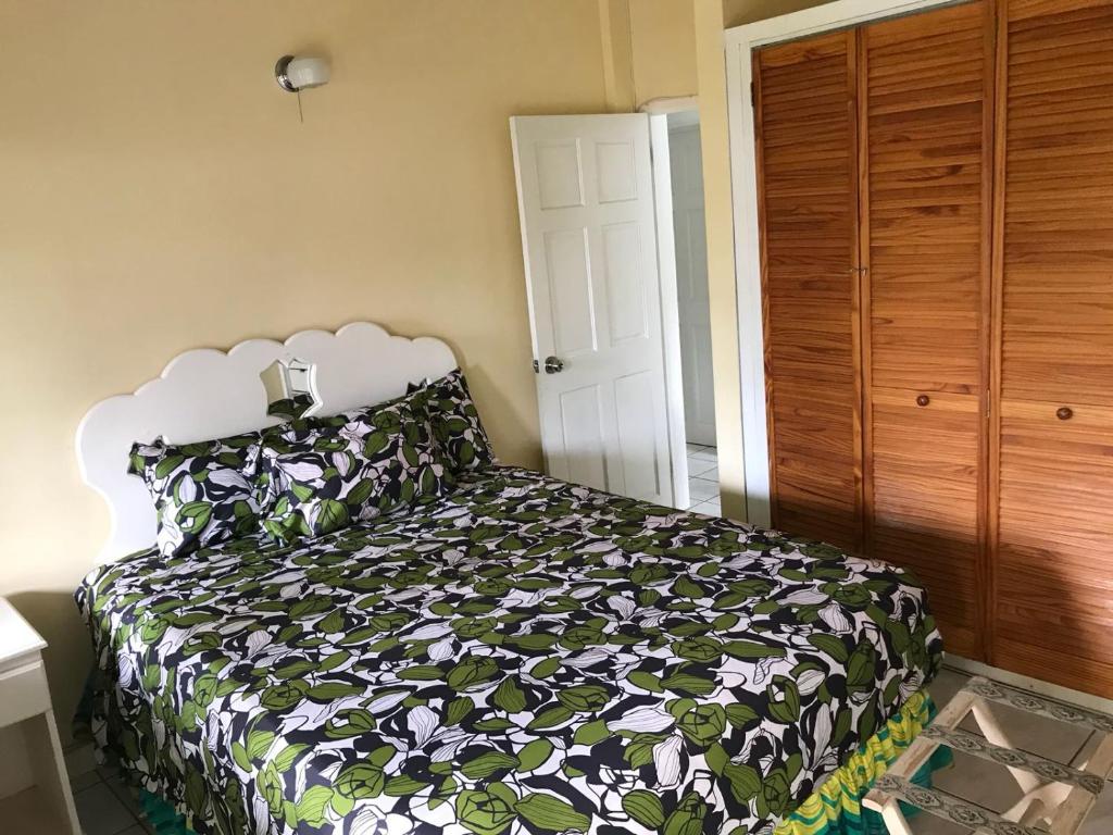 a bedroom with a bed with a black and white comforter at Marvey's Place in Castries