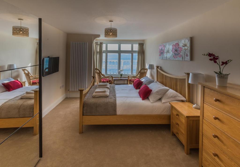 a bedroom with two beds and a television at Beachside Apartment, 1 Pilots Point in Totland