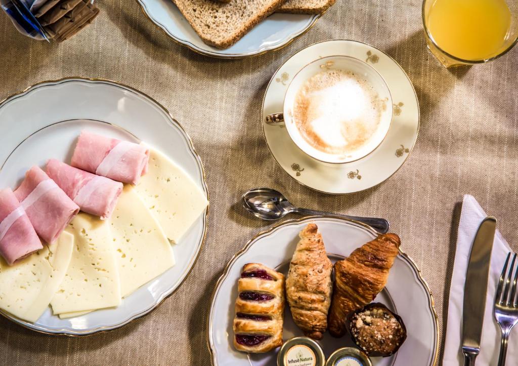 a table with plates of food and a cup of coffee at Rinascimento Bed & Breakfast in Pisa