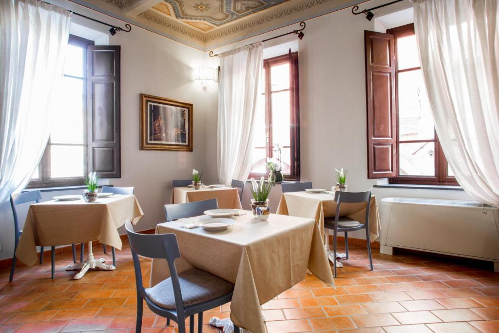 a restaurant with tables and chairs and windows at Rinascimento Bed & Breakfast in Pisa