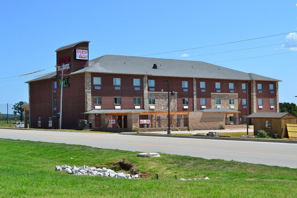 ein großes rotes Backsteingebäude an der Seite einer Straße in der Unterkunft Red River Inn and Suites in Thackerville