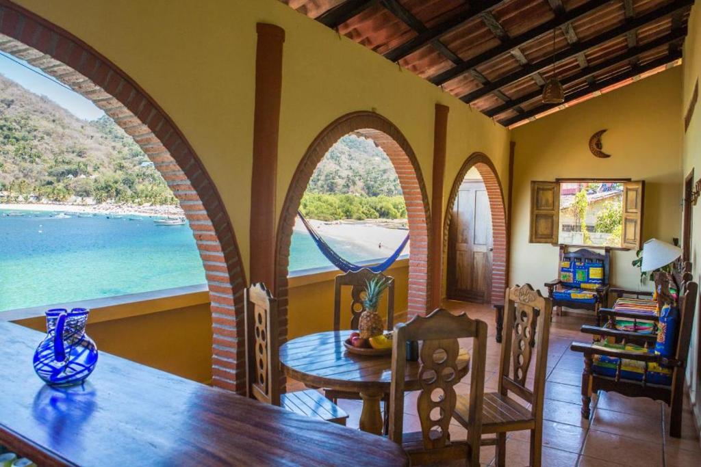 a dining room with a table and a view of the ocean at Casa Frente al mar in Yelapa