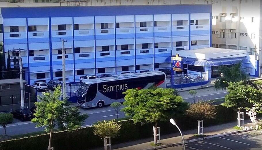 a bus is parked in front of a building at Hotel Estação de Minas in Aparecida