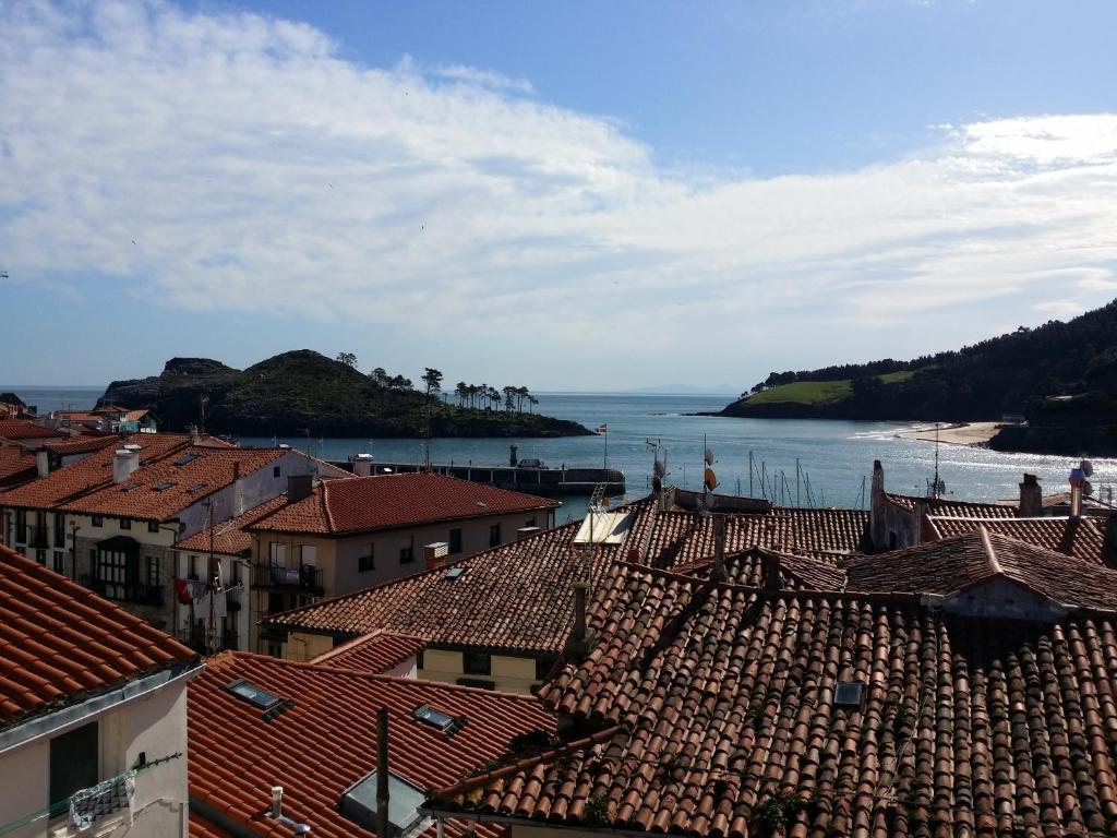 widok na miasto z dachami i ocean w obiekcie Old town Superbistak w mieście Lekeitio