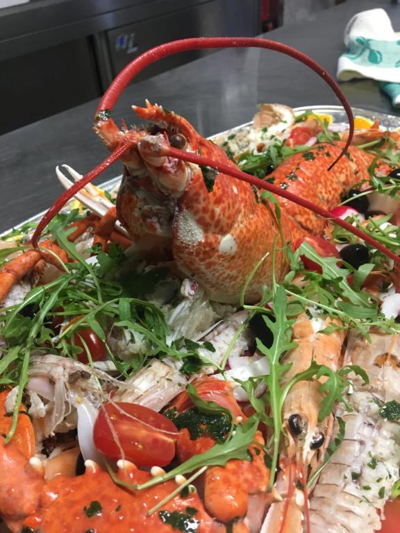 une assiette de nourriture avec du homard et d’autres légumes dans l'établissement Ferrari, à Goro