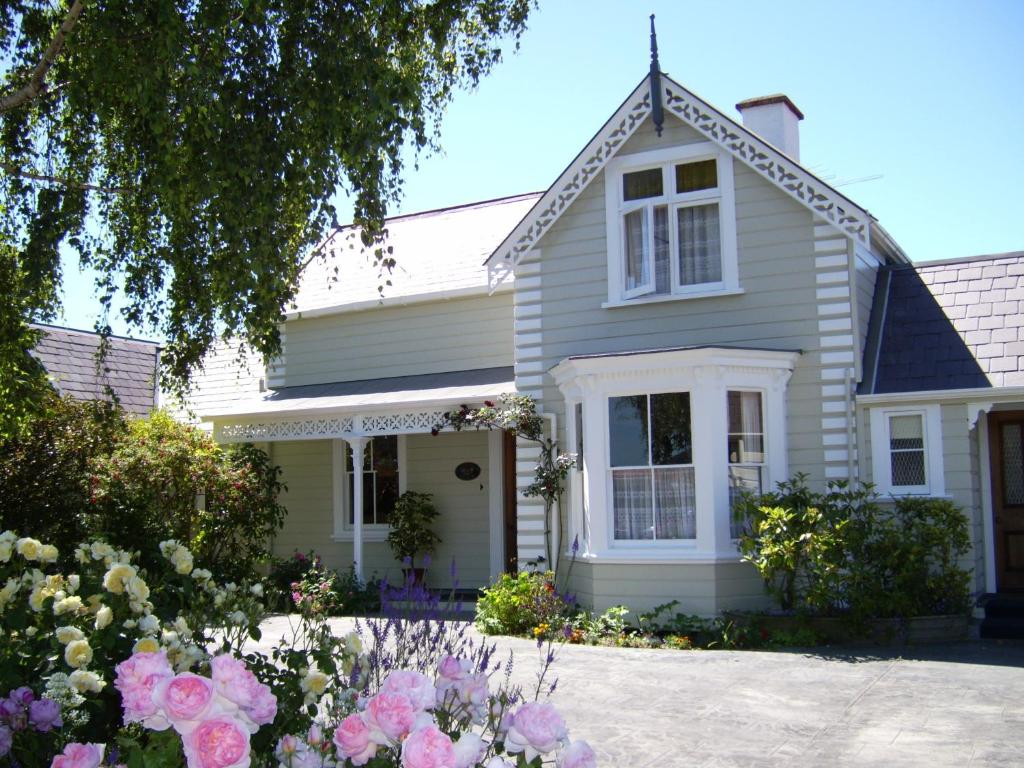 a white house with flowers in front of it at Cambria House in Nelson