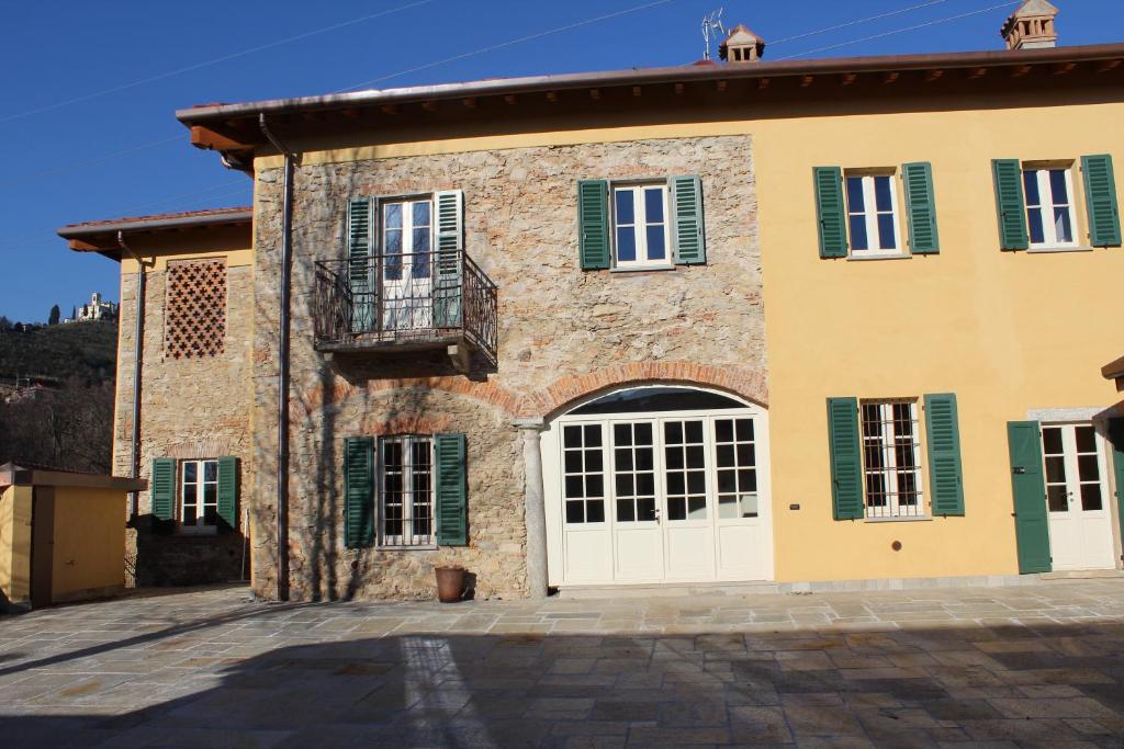 an old stone house with green shutters and a balcony at Il Colombee in Montevecchia