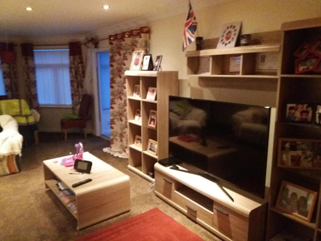 a living room with a large flat screen tv at Southernwind - Spareroom in Stanley