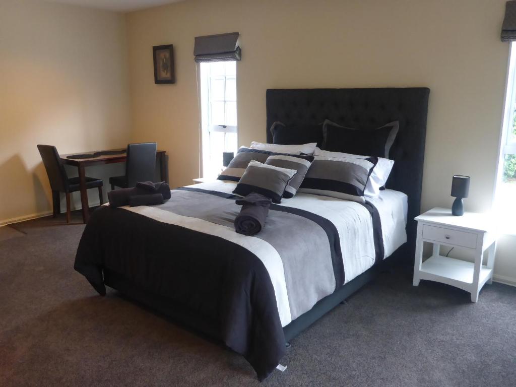 a bedroom with a large bed and a desk at GMH Home Stay in Blenheim