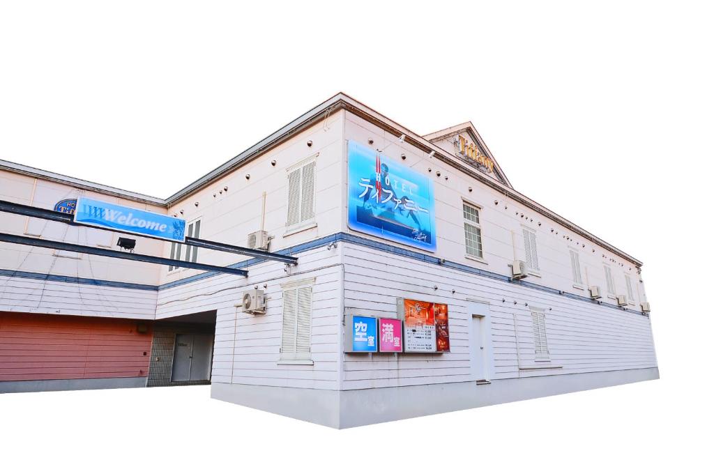 un edificio blanco con un cartel en el costado en Hotel Tiffany (Adult Only) en Asahikawa