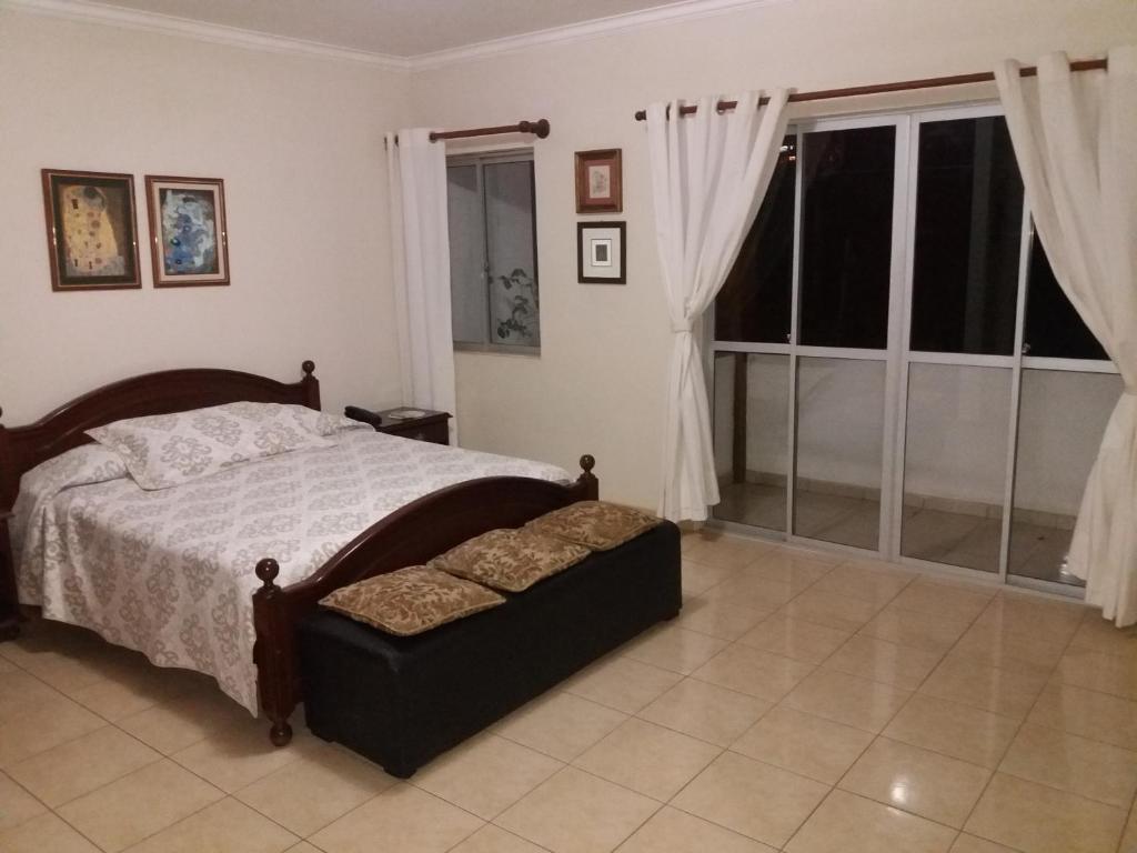 a bedroom with a bed and a large window at Feria Exposición Condominio Nieves in Santa Cruz de la Sierra