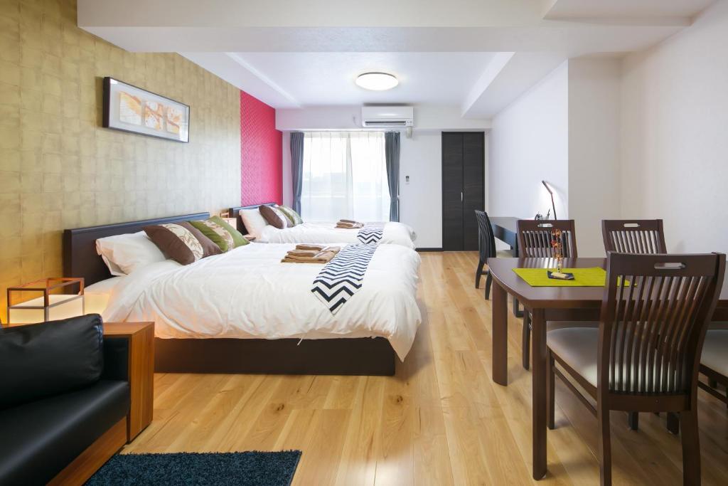 1 dormitorio con 1 cama, mesa y sillas en Minn Machiya en Tokio
