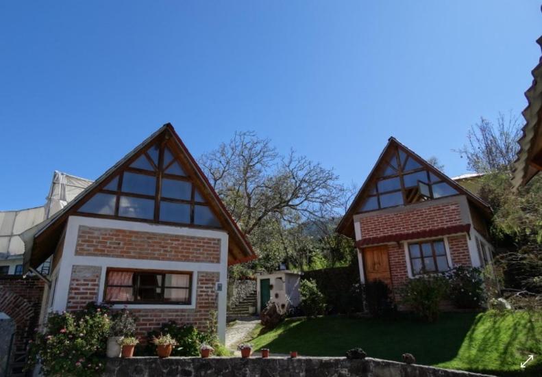 une maison avec deux toits mansardés et une cour dans l'établissement Posada Santa María, à Mineral del Chico