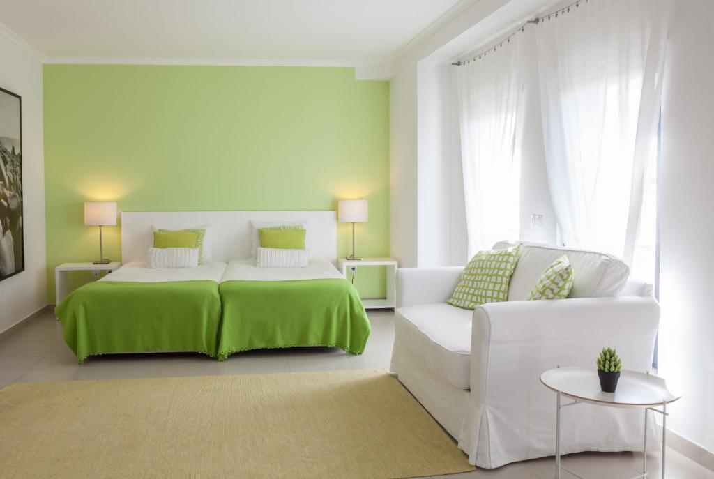 Habitación blanca con cama y sofá en Hotel Alcatruz, en Aljezur
