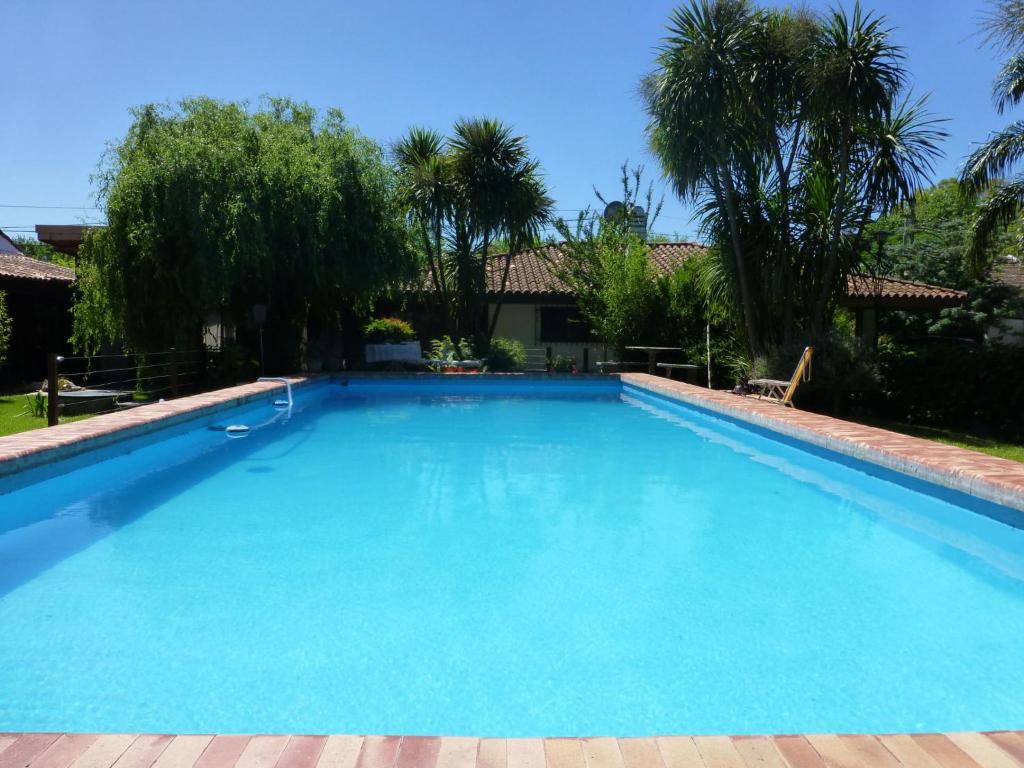 einen großen Pool in einem Garten mit Palmen in der Unterkunft Casaquinta City Bell in City Bell