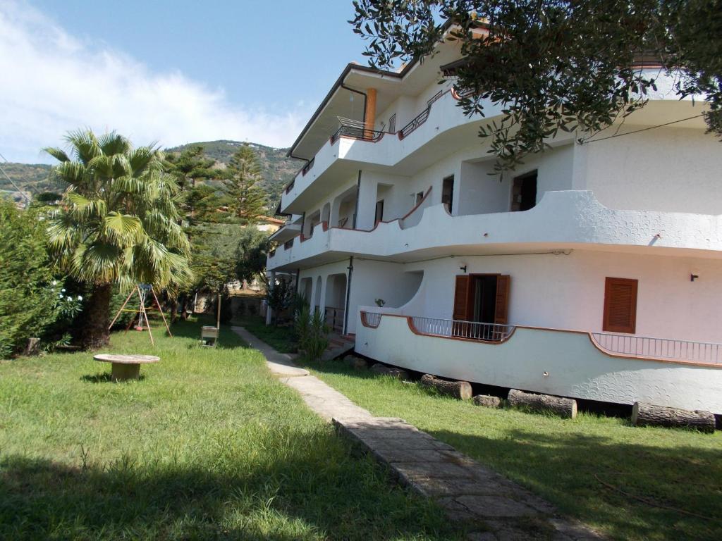 ein großes weißes Gebäude mit einem Park im Gras in der Unterkunft Apartments Agostino in Ioppolo