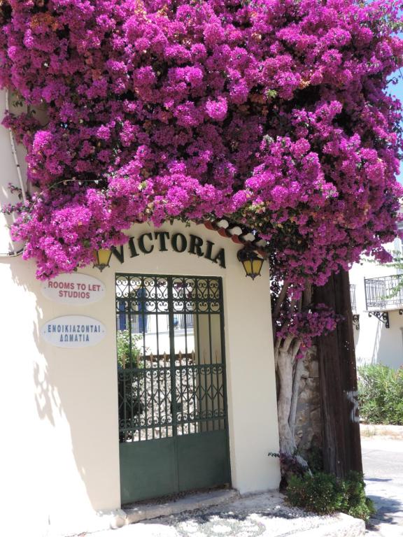 una puerta con flores púrpuras en un edificio en Victoria Studios en Spétses