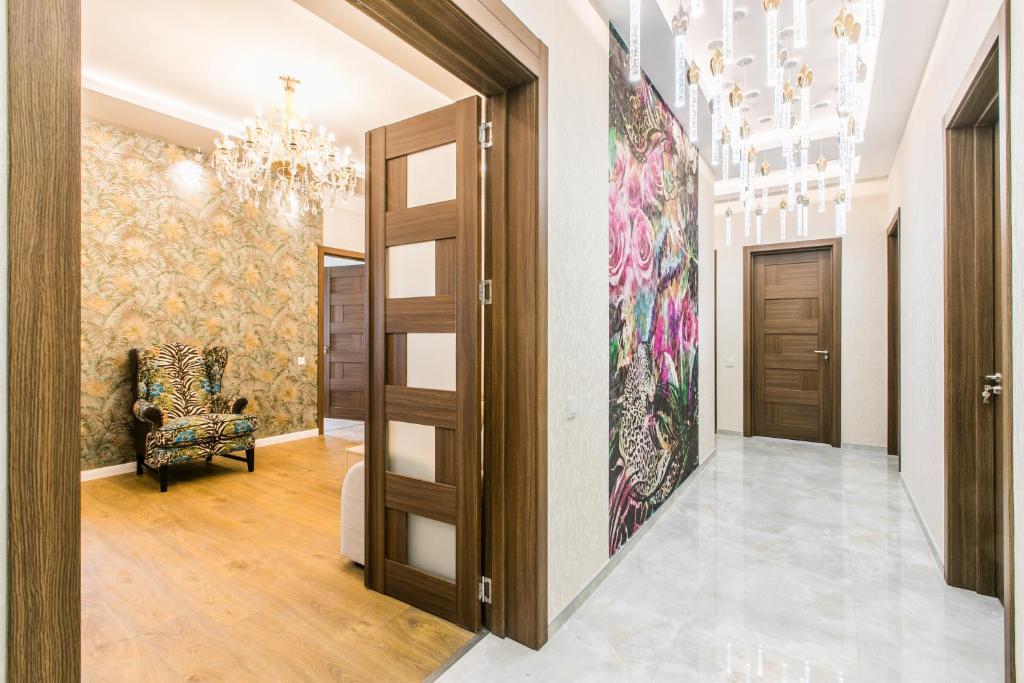 a hallway with a painting on the wall and a chandelier at Sweet Home 6 VIP at Rustaveli Avenue in Tbilisi City