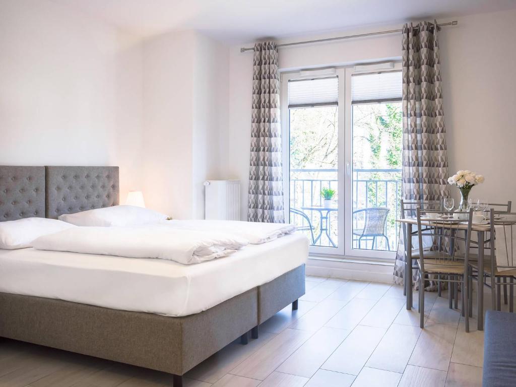 um quarto com uma cama, uma mesa e uma janela em VacationClub - Aquamarina Apartment C-06 em Świnoujście