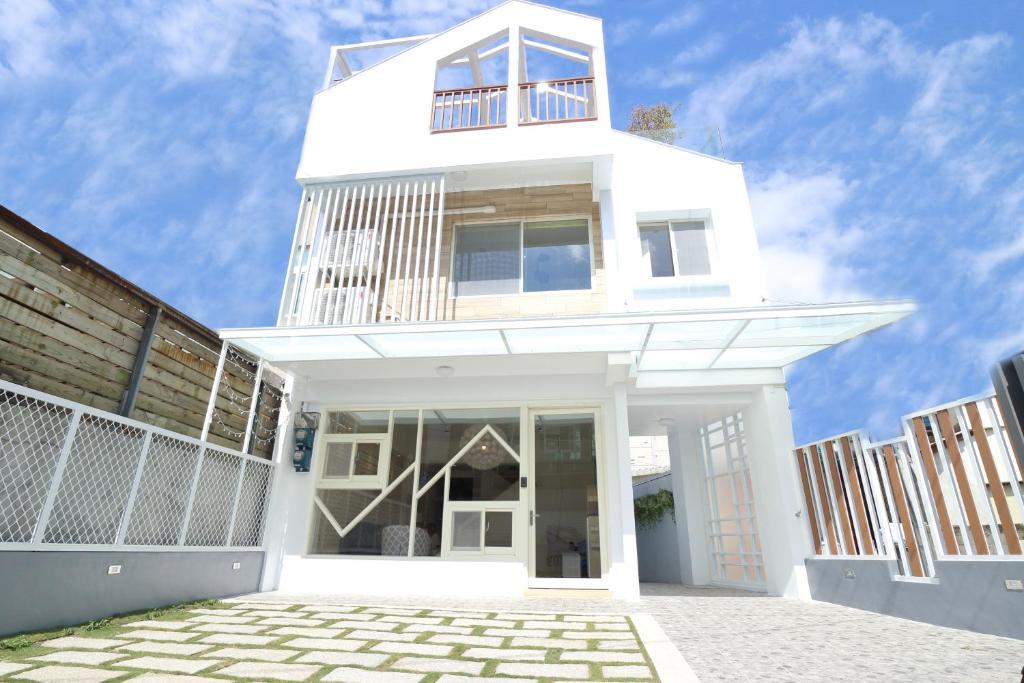 Un edificio blanco con un balcón en la parte superior. en 爸爸萬歲 PA Pa B&b 民宿2143號, en Hualien City
