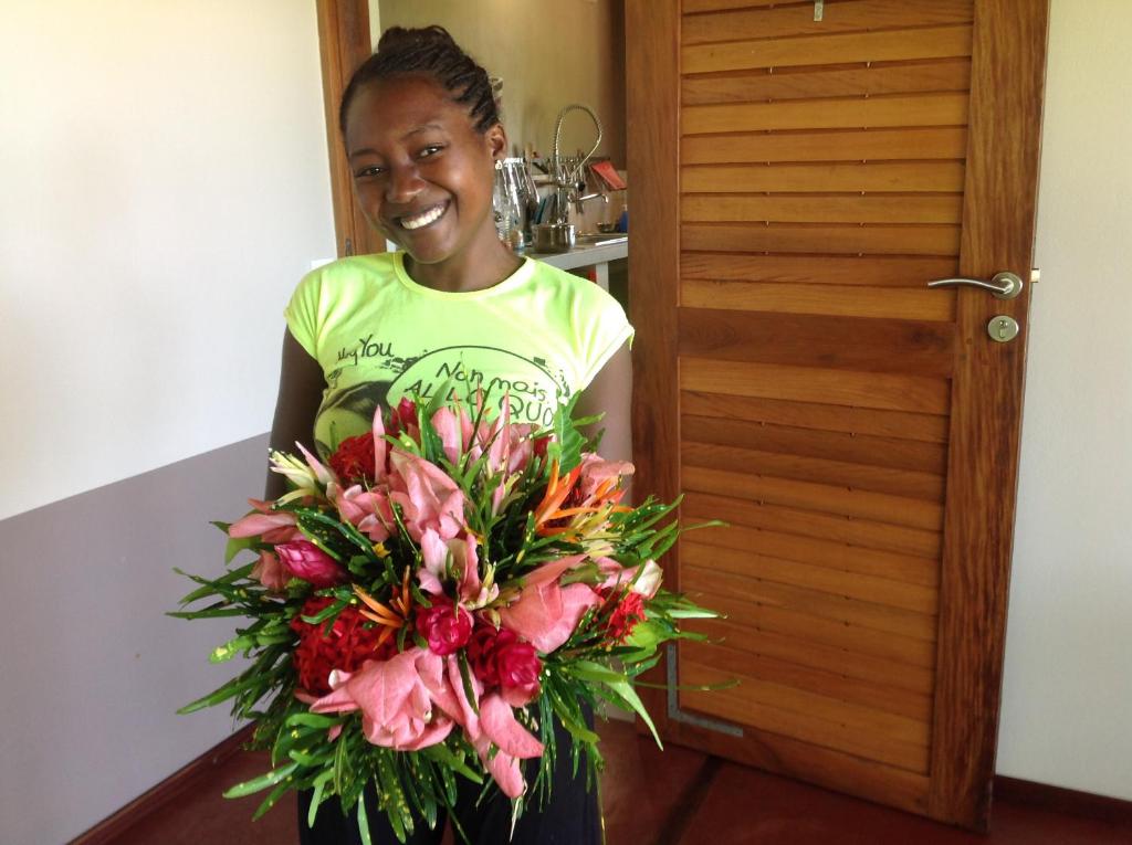 a young girl holding a bouquet of flowers at Coco Komba Lodge in Nosy Komba