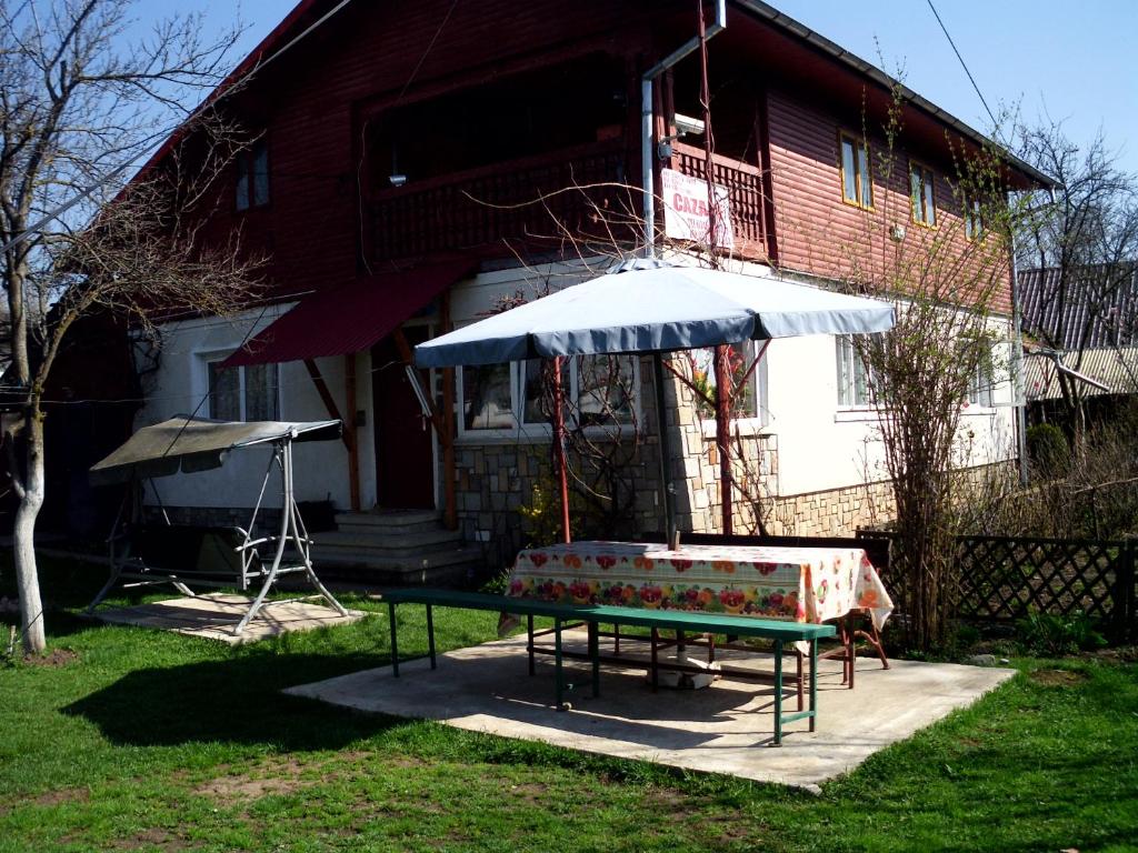 a table and an umbrella in front of a house at Vila Mihaela in Breaza