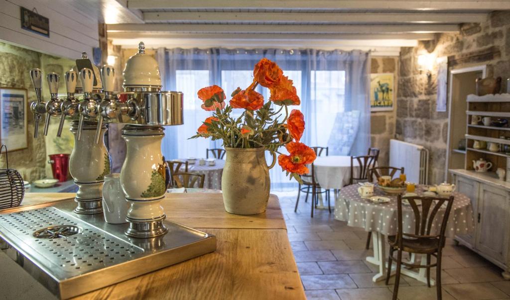 eine Küche mit zwei Vasen mit Blumen auf dem Tisch in der Unterkunft Chambres d'hôtes Andrea in Brive-la-Gaillarde