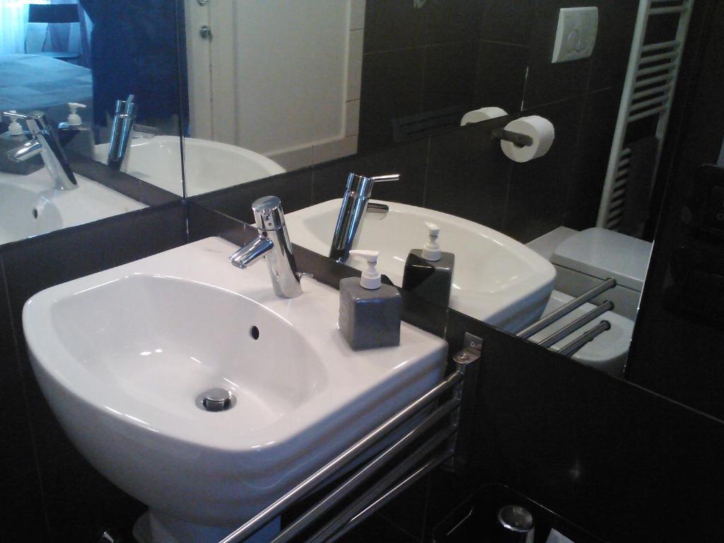 ein Badezimmer mit einem weißen Waschbecken und einem Spiegel in der Unterkunft B&B Verdeblu in Mantua