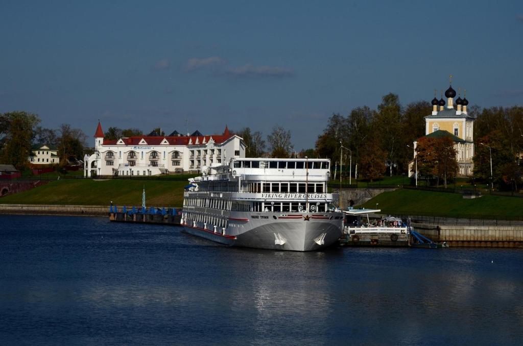 um navio de cruzeiro atracado numa doca em frente a uma casa em AZIMUT Hotel Uglich em Uglich