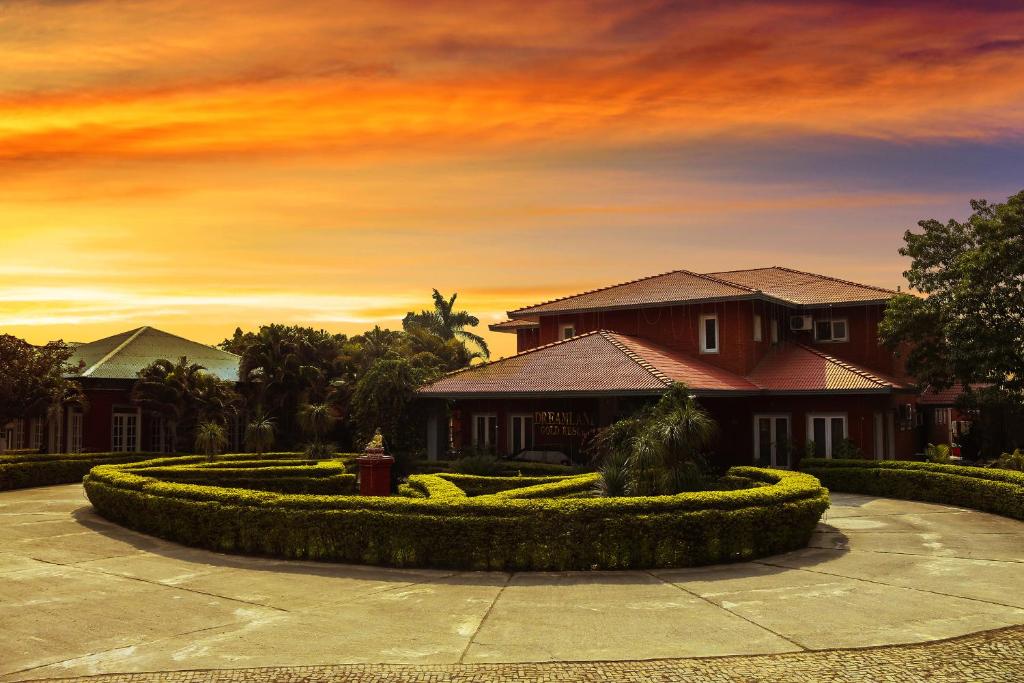 una casa con jardín frente a la puesta de sol en Dreamland Gold Resort & Hotel, en Bhairāhawā