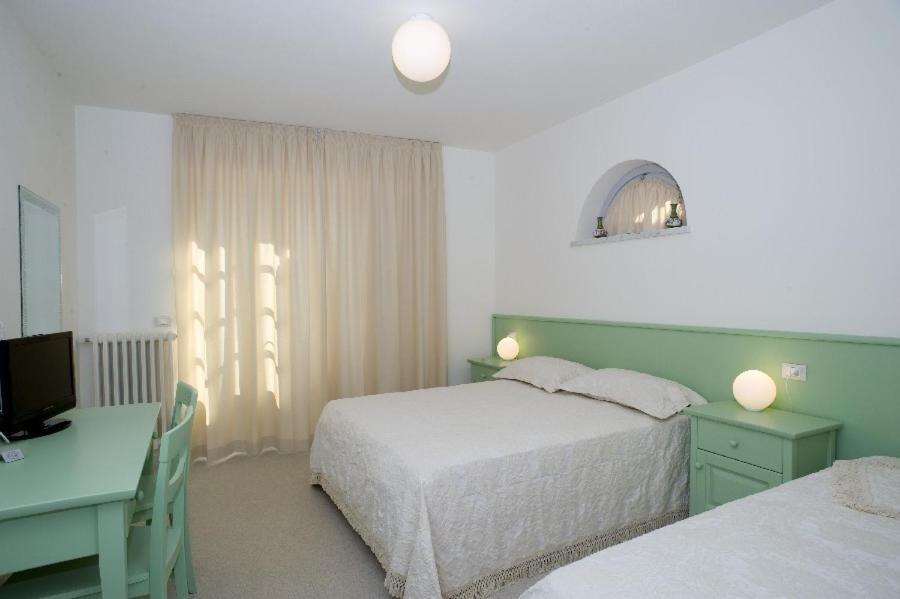 a bedroom with two beds and a desk and a television at LIù B&B in Torre del Lago Puccini