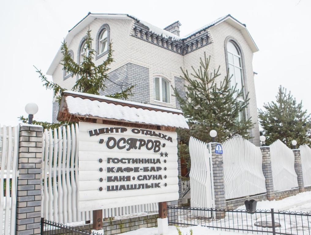 una casa con un cartel delante de ella en Mini-hotel Ostrov en Aleksandrov
