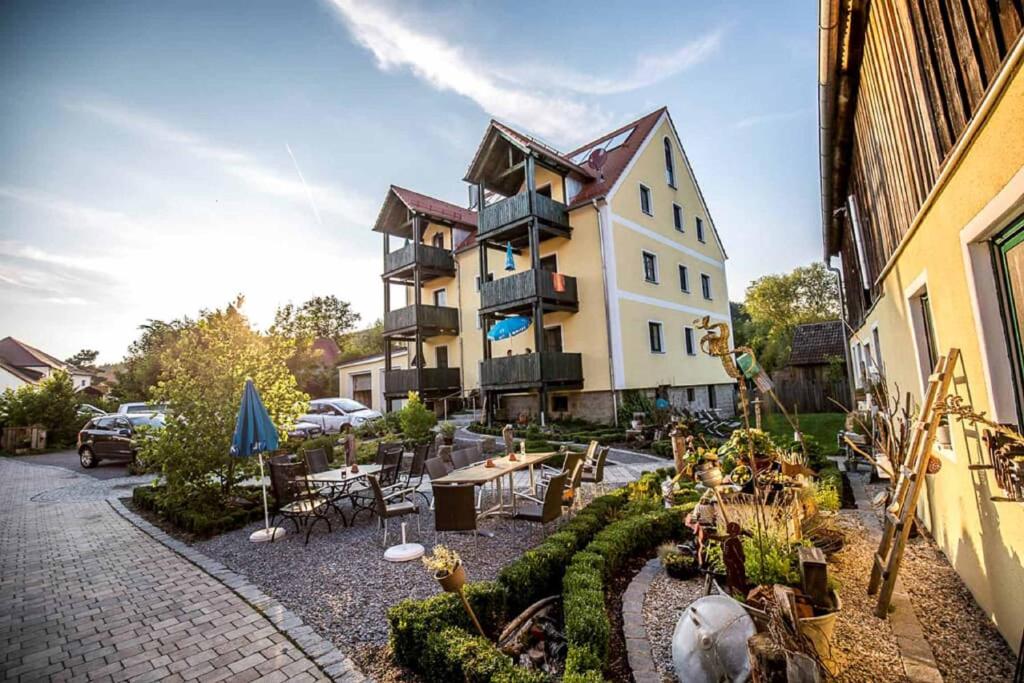 un grand bâtiment avec une cour dotée de tables et de chaises dans l'établissement Müllner-Hof, à Schwarzach bei Nabburg