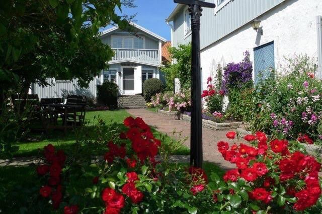 dom z kwiatami na podwórku w obiekcie Gammalsbygårdens Gästgiveri w mieście Degerhamn