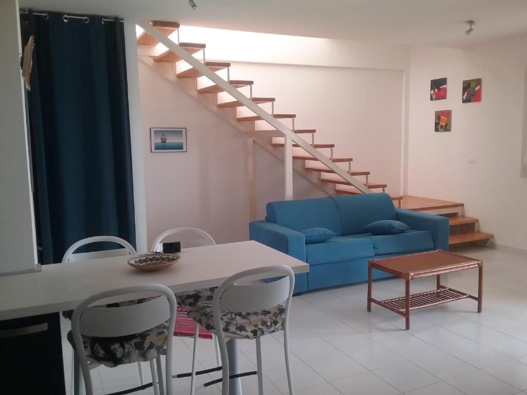 uma sala de estar com um sofá azul e uma mesa em Splendido Appartamento 50mt dal mare em Marzamemi