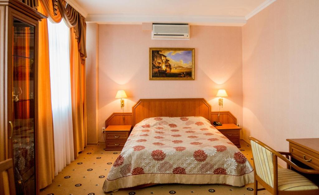 - une chambre avec un lit, deux tables et deux lampes dans l'établissement Profit Hotel, à Toula