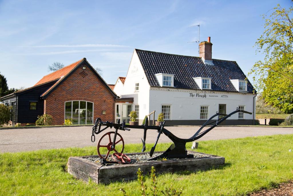 a statue in the grass in front of a building at The Plough in Wangford