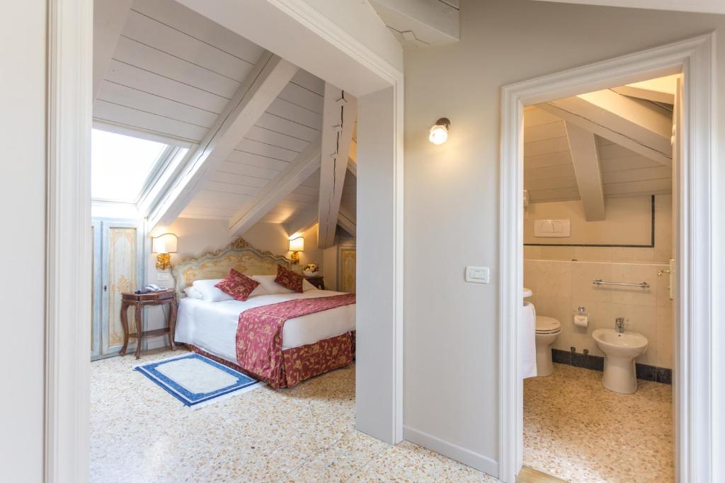 a bedroom with a bed and a toilet in a room at Hotel Tiziano in Venice
