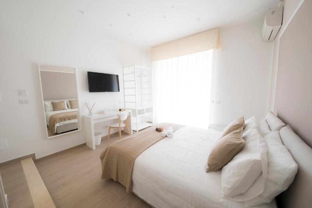 サレルノにあるシェリー B&B サレルノの白いベッドルーム(大型ベッド1台、テレビ付)