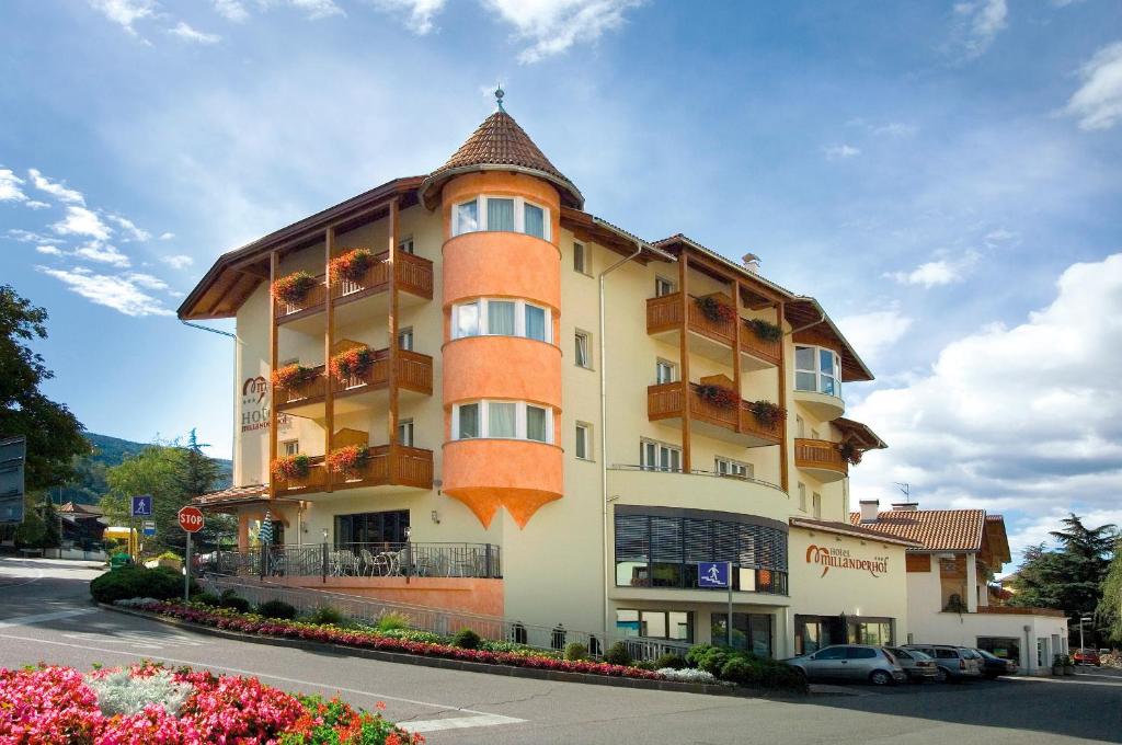 un grande edificio arancione con balconi su strada di Hotel Millanderhof a Bressanone