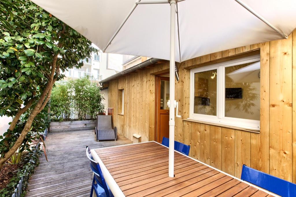 アルカションにあるLocation avec terrasseの木製のデッキ(家の上に傘付)