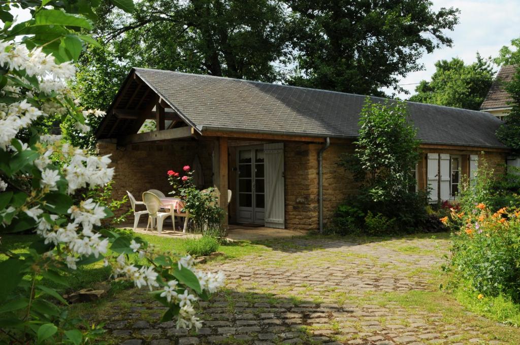 un cottage avec une table et des chaises dans le jardin dans l'établissement Gite THEYS Floing, à Floing