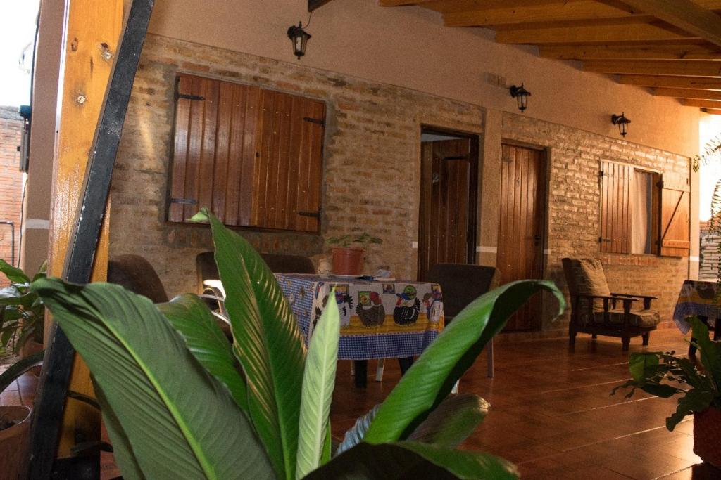 a dining room with a table and a brick wall at Duplex Macuco in Puerto Iguazú