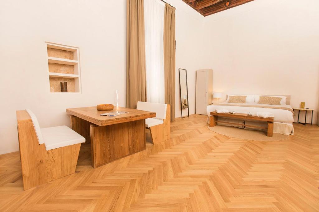 a room with a wooden table and a bed at ICON Rosetó in Palma de Mallorca