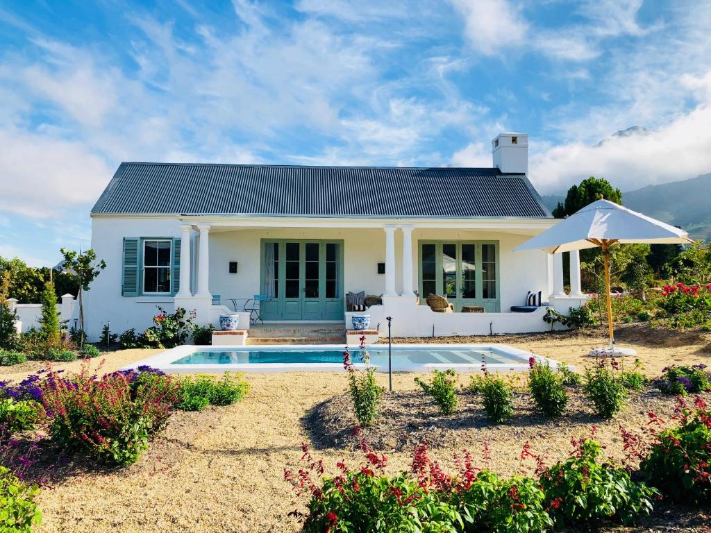 a house with a swimming pool in the yard at La Cotte Orchard Cottages in Franschhoek