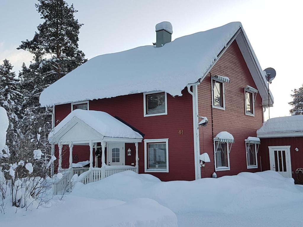 uma casa vermelha com neve em cima em Villa Mia em Vidsel