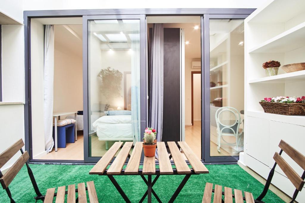 una habitación con una mesa y sillas en una alfombra verde en Setefilla Deluxe Suite by Valcambre, en Sevilla
