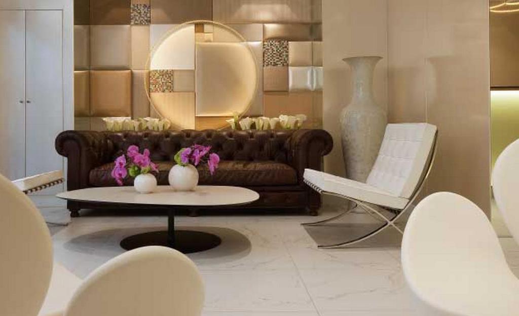 a living room with a couch and a table and chairs at Le 7 Eiffel Hotel by Malone in Paris